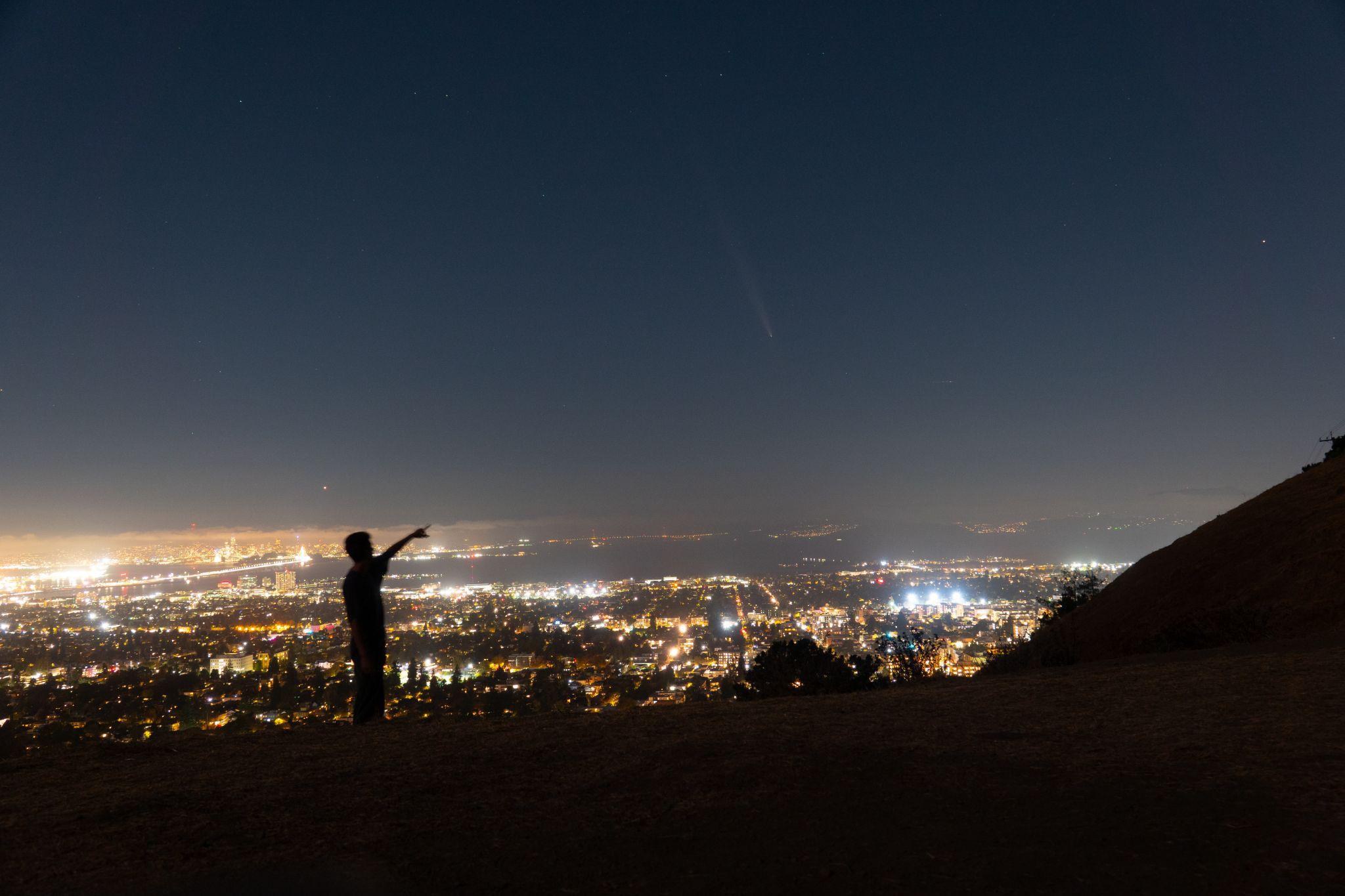 Adam pointing out Comet Tsuchinshan-ATLAS above the city lights, from the Berkeley fire trails