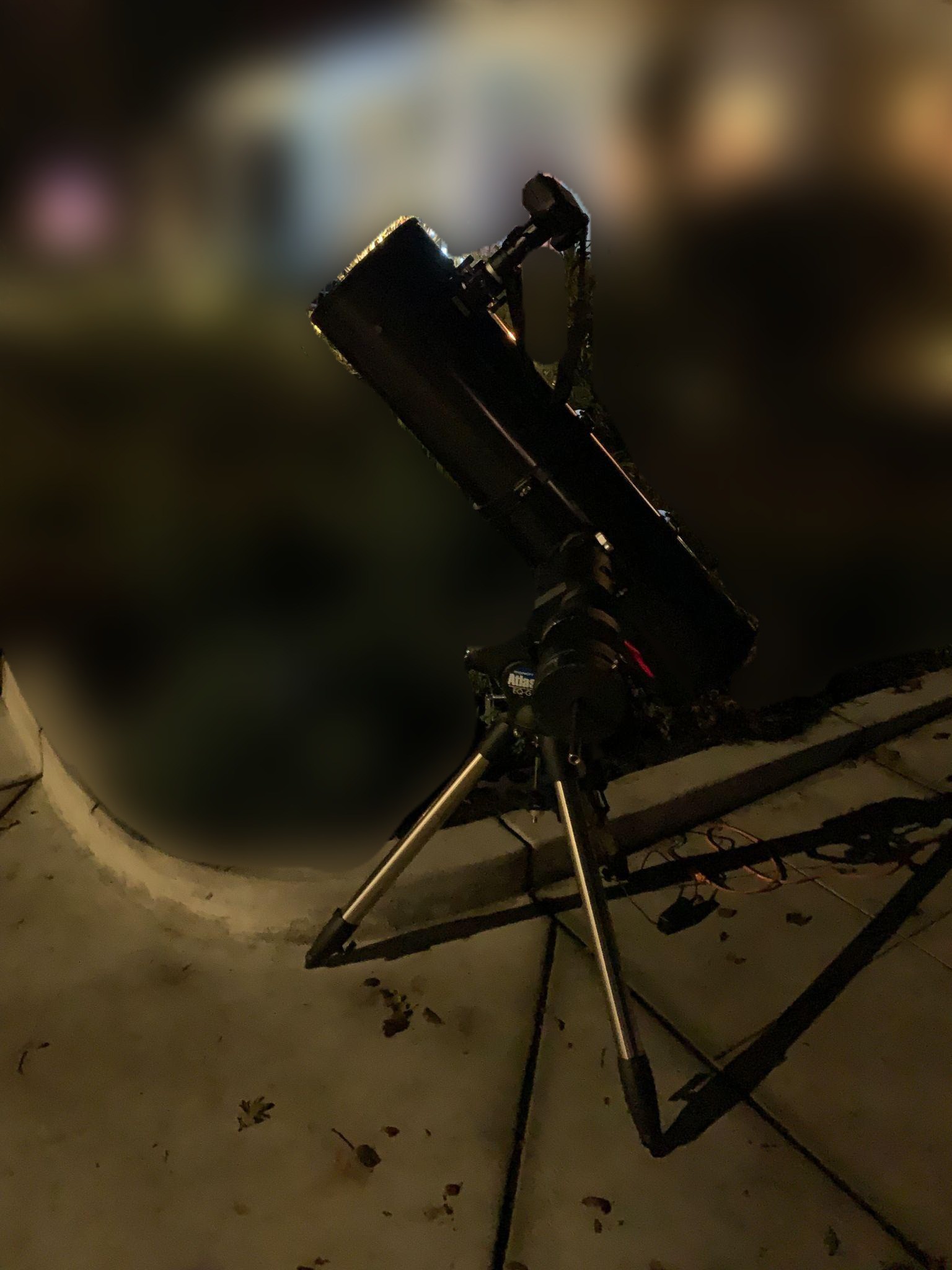 A 10 inch reflector telescope set up outdoors at night